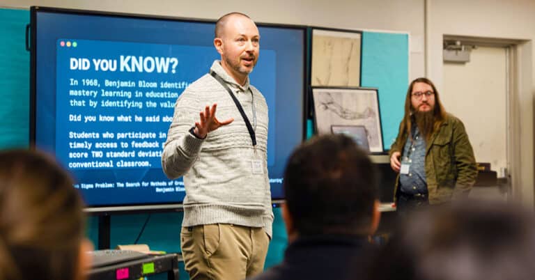 Two men present in front of a room full of educators.